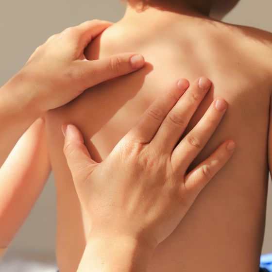 Osteopathische Behandlung am Rücken eines Kindes