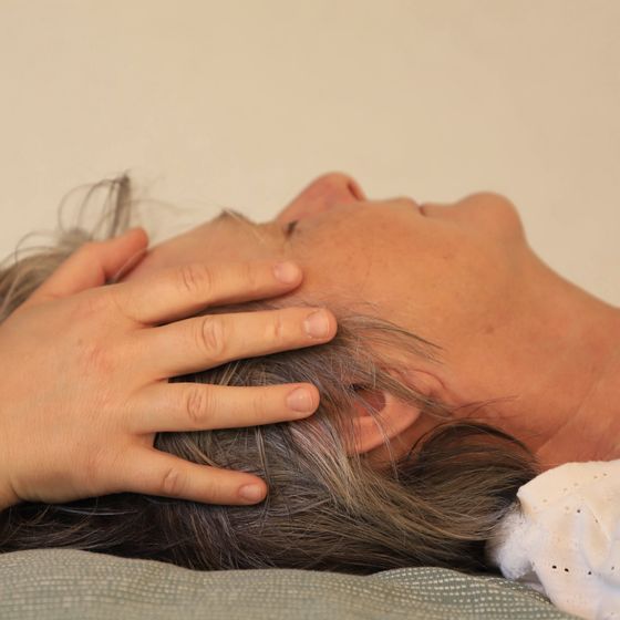 Osteopathische Behandlung am Kopf einer erwachsenen Patientin